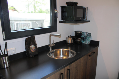 Kleine keuken met spoelbak, waterkoker, koffiemachine en magnetron in Cuckoo’s Nest, Camping de Koeksebelt.