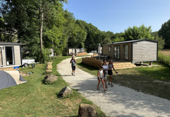 Mobilhome Toulouse in La Draille, Frankreich: Menschen gehen auf Wegen zwischen modernen Lodges.