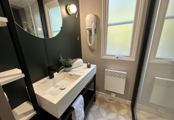 Moderne badeværelse i Mobilhome Toulouse på La Draille, Frankrig, med vask, spejl og vinduer.