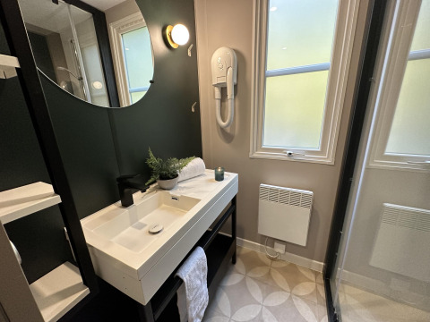 Moderne badkamer bij Mobilhome Toulouse op La Draille, Frankrijk, met wastafel, spiegel en ramen.