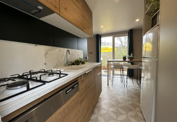 Cucina moderna nel Mobilhome Toulouse a La Draille, Francia, con tavolo da pranzo e vista terrazza.