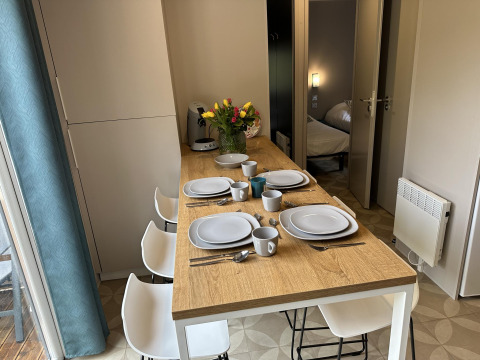 Table dressée pour quatre dans un Mobilhome Toulouse à La Draille, France, fleurs et ambiance chaleureuse.
