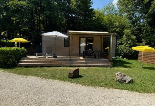 Mobilhome Toulouse en La Draille, Francia, con terraza, tumbonas y sombrillas amarillas entre zonas verdes.