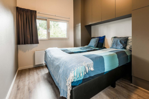 Modernes Schlafzimmer mit zwei Einzelbetten in der Lodge Module II, Landgoed de Scheleberg, Niederlande.