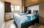 Dormitorio moderno con dos camas individuales en la Lodge Module II de Landgoed de Scheleberg, Países Bajos.