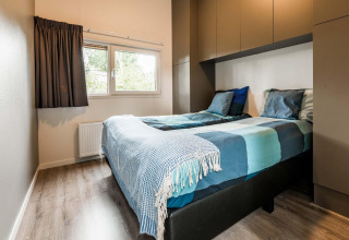 Modernes Schlafzimmer mit zwei Einzelbetten in der Lodge Module II, Landgoed de Scheleberg, Niederlande.