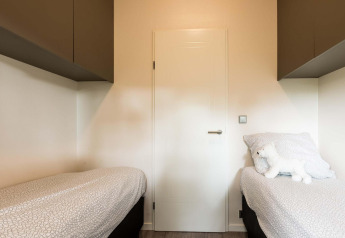 Schlafzimmer mit zwei Einzelbetten, weißer Bettwäsche und einem Plüschtier in Module II, Landgoed de Scheleberg, Niederlande.