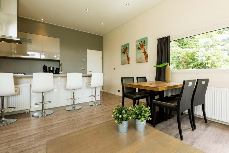 Cocina y comedor modernos en la cabaña Module II de Landgoed de Scheleberg, Países Bajos, con decoración clara.