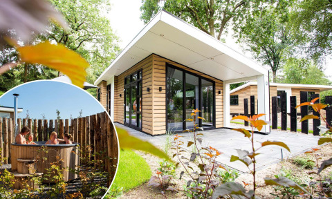 Alojamiento glamping moderno con fachada de madera, grandes ventanales y jacuzzi exterior privado.