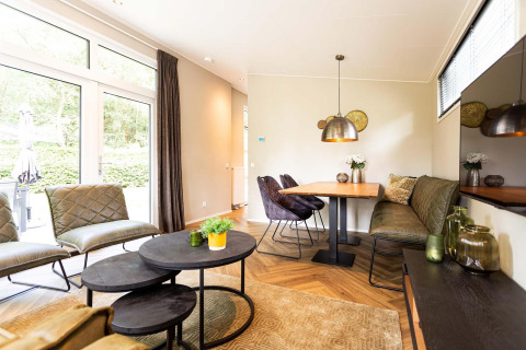 Bright, modern lodge living room with large windows, a cozy seating area, and a dining nook in the corner.