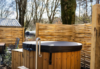 Bañera de hidromasaje de madera al aire libre con escalera en Heuvelrug Cottage, De Thijmse Berg, Países Bajos.