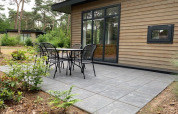 Buiten terras aan een tiny house in Forest park chalet bij Holiday park De Kleine Belties, Nederland, met zitjes.