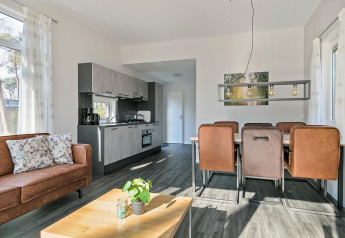 Bright interior of Forest park chalet at Holiday park De Kleine Belties, Netherlands, with sofa and dining table.