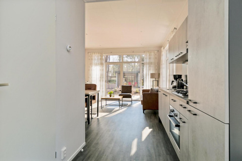 Lichte woonkamer en keuken in een tiny house bij Forest park chalet, Holiday park De Kleine Belties, Nederland.