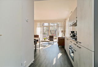 Bright living room and kitchen in a tiny house at Forest park chalet, Holiday park De Kleine Belties, Netherlands.