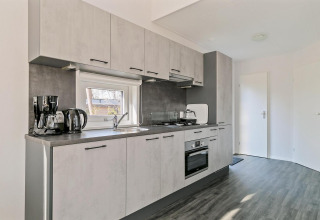 Modern compact kitchen in Forest Park Chalet at Holiday park De Kleine Belties, the Netherlands.
