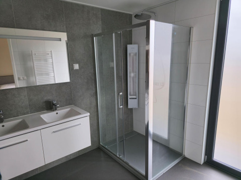 Baño moderno con ducha de vidrio y dos lavabos en Water lodge 2 Deluxe en Hofparken Wiltershaar, Países Bajos.