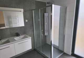 Baño moderno con ducha de vidrio y dos lavabos en Water lodge 2 Deluxe en Hofparken Wiltershaar, Países Bajos.