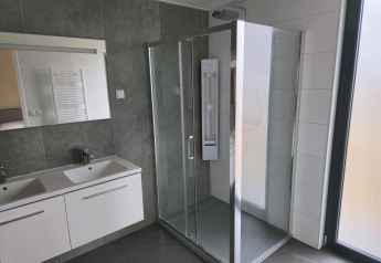 Baño moderno con ducha de vidrio y dos lavabos en Water lodge 2 Deluxe en Hofparken Wiltershaar, Países Bajos.