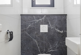 Modernes WC im Forest Lodge DeLuxe, Kampeerdorp de Zandstuve, Niederlande, mit Marmorverkleidung.