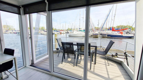 Husboat Havenlodge N på Marina Parcs Naarden i Holland med udsigt over marinaens lystbåde fra terrassen.