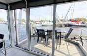 Husboat Havenlodge N på Marina Parcs Naarden i Holland med udsigt over marinaens lystbåde fra terrassen.
