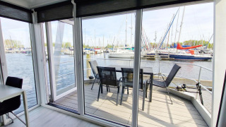 Woonboot Havenlodge N bij Marina Parcs Naarden in Nederland, uitzicht op de haven en jachten vanaf het dek.