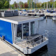 Moderna houseboat blu Havenlodge N attraccata a Marina Parcs Naarden nei Paesi Bassi, con barche vicine.