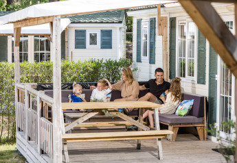Une famille se détend ensemble sur la terrasse de leur chalet à Kampeerdorp de Zandstuve, aux Pays-Bas.