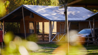 Tienda safari en Rheezerlodge, Kampeerdorp de Zandstuve en Países Bajos, rodeada de naturaleza y árboles.