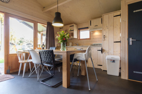 Modern dining area inside Rheezerlodge safari tent at Kampeerdorp de Zandstuve in the Netherlands.