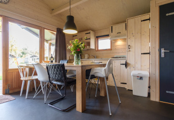 Moderne indretning af et safari-telt på Rheezerlodge, Kampeerdorp de Zandstuve, Holland, med spisebord.