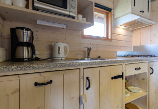 Keuken in Rheezerlodge, Kampeerdorp de Zandstuve, met koffiezetapparaat, waterkoker en kookplaat.