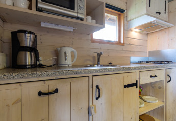 Espace cuisine au Rheezerlodge, Kampeerdorp de Zandstuve, avec cafetière, bouilloire et cuisinière.