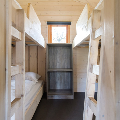 Wooden bunk beds and shelving inside a safari tent at Rheezerlodge, Kampeerdorp de Zandstuve, Netherlands.