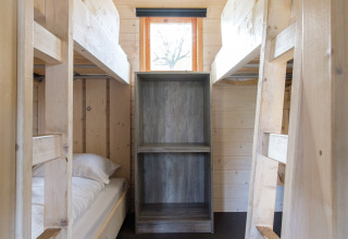 Houten stapelbedden en een kast in een safaritent bij Rheezerlodge, Kampeerdorp de Zandstuve, Nederland.