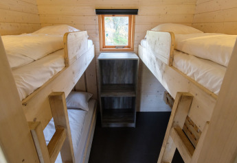 Chambre avec lits superposés en bois dans la Rheezerlodge, tente safari au Kampeerdorp de Zandstuve.