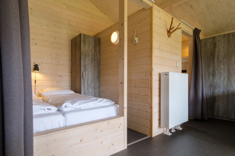 Interni moderni in legno in una tenda safari al Rheezerlodge, Kampeerdorp de Zandstuve, Paesi Bassi.