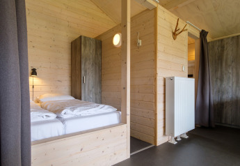 Modernes, holzverkleidetes Schlafzimmer im Safari-Zelt Rheezerlodge, Kampeerdorp de Zandstuve, Niederlande.