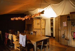 Gezellige eetruimte in een houten hut met lichtjes, bij Feather Down Hoeve de Betuwe, Gelderland.