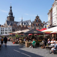 Terraza de café al aire libre con personas disfrutando del sol cerca de Dreumel, Gelderland, Países Bajos.