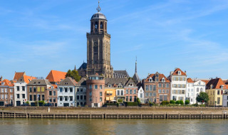 Vue sur la rivière, les maisons historiques et le clocher de l’église à Deventer, Overijssel, Pays-Bas, un jour ensoleillé.