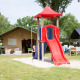 Bambini giocano su uno scivolo rosso davanti a tende safari al Camping 't Veld nei Paesi Bassi.