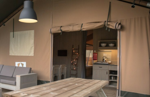 Comfort Safari-tent bij Camping 't Veld in Nederland, met moderne inrichting en knusse keukenhoek.