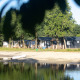 Case sulla spiaggia al Camping 't Veld nei Paesi Bassi, sulle rive del lago con persone e una canoa.