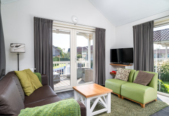 Lichte woonkamer in lodge Meine bij Tusken de Marren in Nederland, modern ingericht met terraszicht.