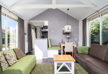 Lichte, moderne leefruimte in lodge Meine bij Tusken de Marren in Nederland met grote raampartijen.