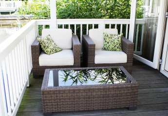 Gemütliche Terrasse mit zwei Korbsesseln, Kissen und Tisch in der Lodge Meine bei Tusken de Marren, Niederlande.