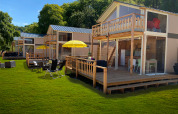 Tienda tipo lodge de lujo Belle Vue en La Draille, Francia, con terrazas de madera y césped verde.