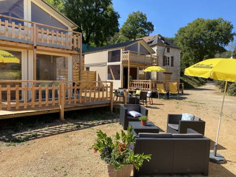 Gemütliche Outdoor-Lounge mit gelben Sonnenschirmen bei Luxury lodge tent Belle Vue, La Draille in Frankreich.